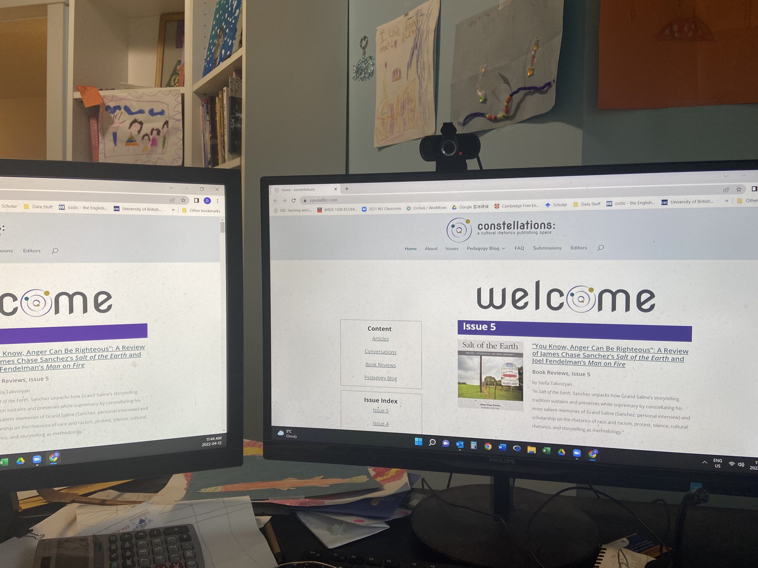 A picture of dual computer monitors in a home office open to the constellations website.
